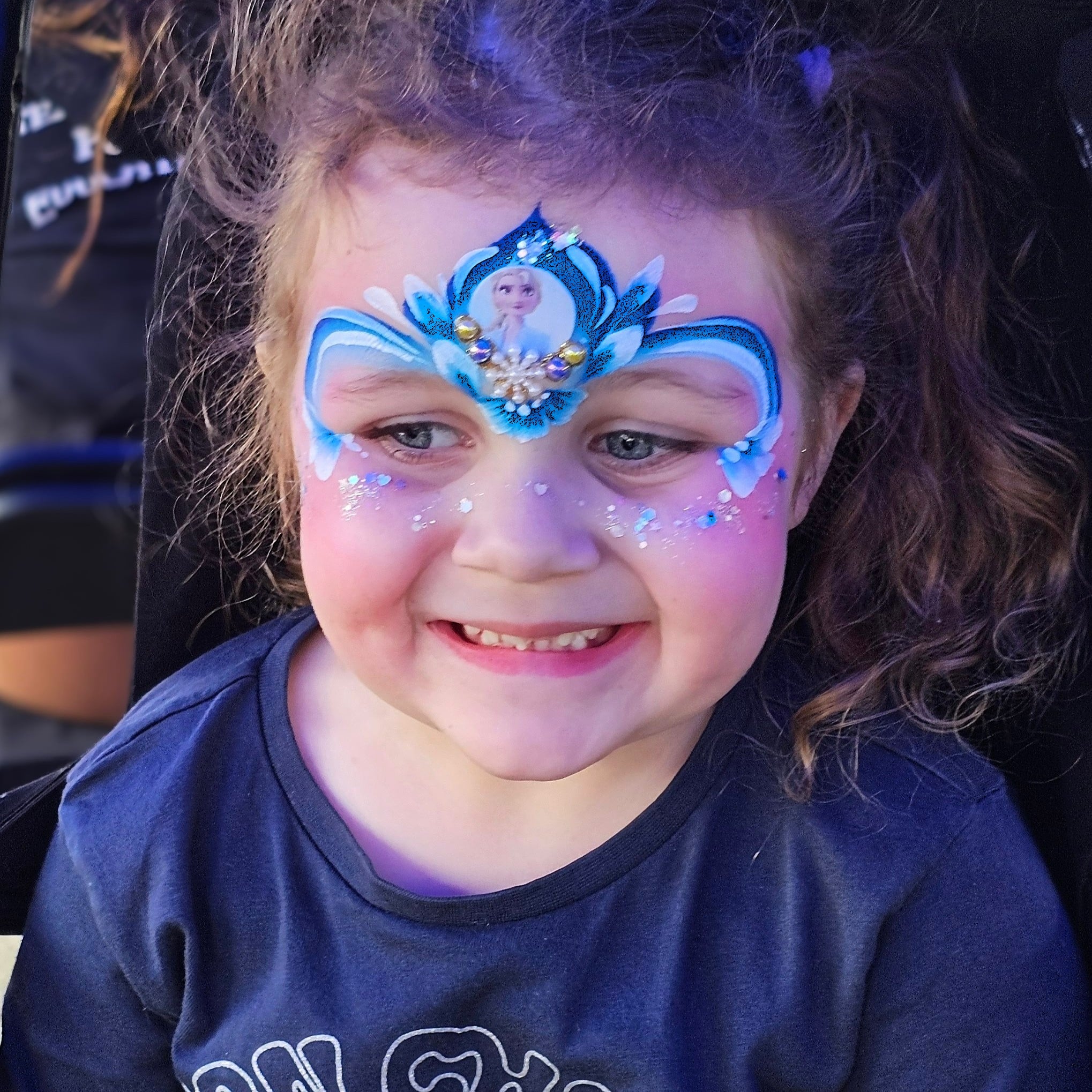 Little girl with frozen face painting with a face gem