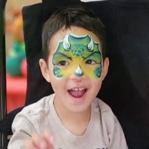 A child with a dinosaur face paint