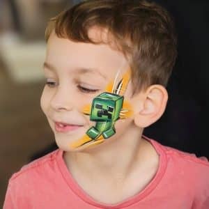 A child with a Minecraft design painted on their face.