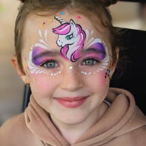 A child with a unicorn face painting