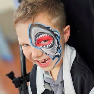 A child with a shark painted on their face